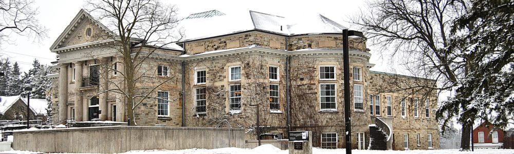 The stone Creelman Hall building in winter with snow