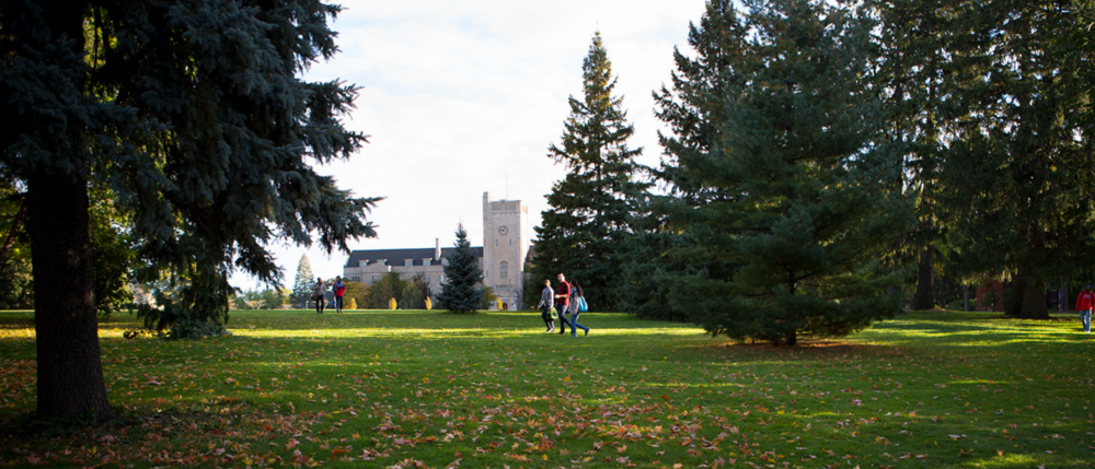 Students walk across Johnston Green on a sunny day, with Johnston Hall in the background.
