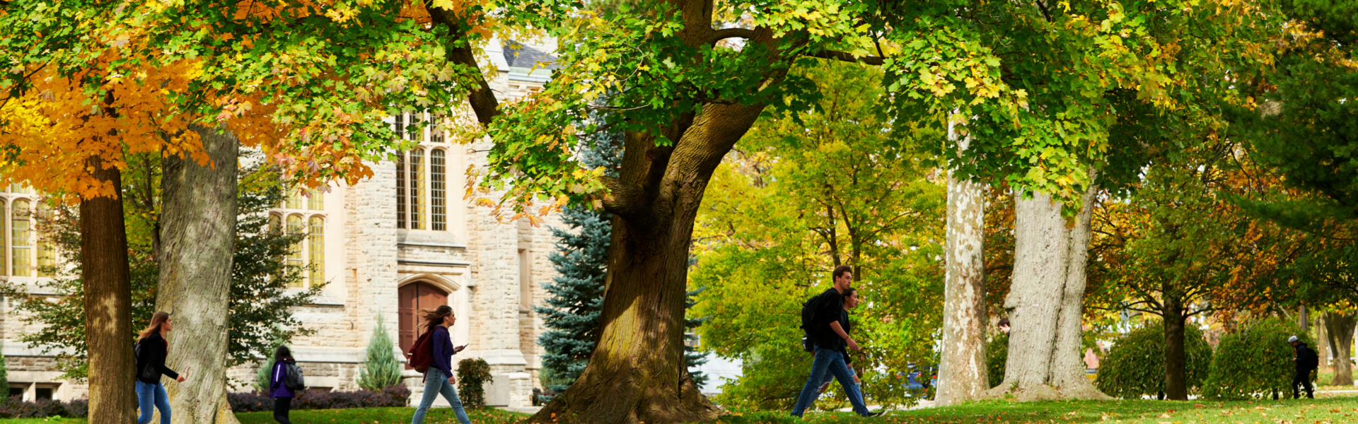 Students walk in front of War Memorial Hall on a fall day.