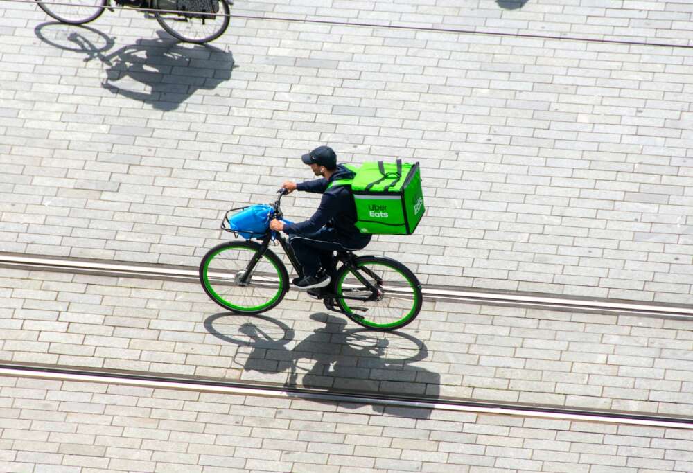 A man riding a bike down a street.