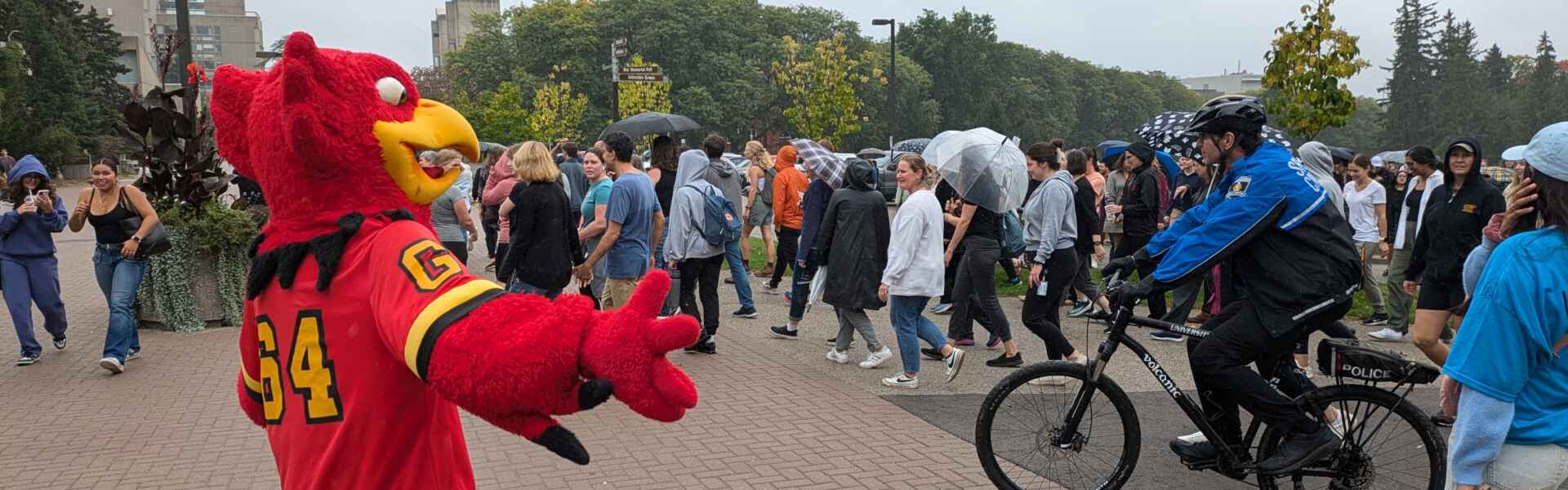 Gryph directs people participating in campus mile.