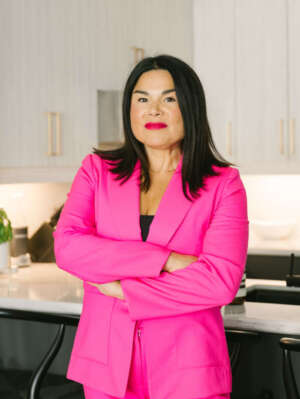 Headshot of Jenn Harper, wearing a pink blazer with her arms crossed.