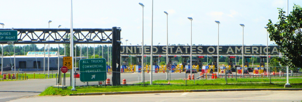 a roadway leads into a border crossing that says united states of america