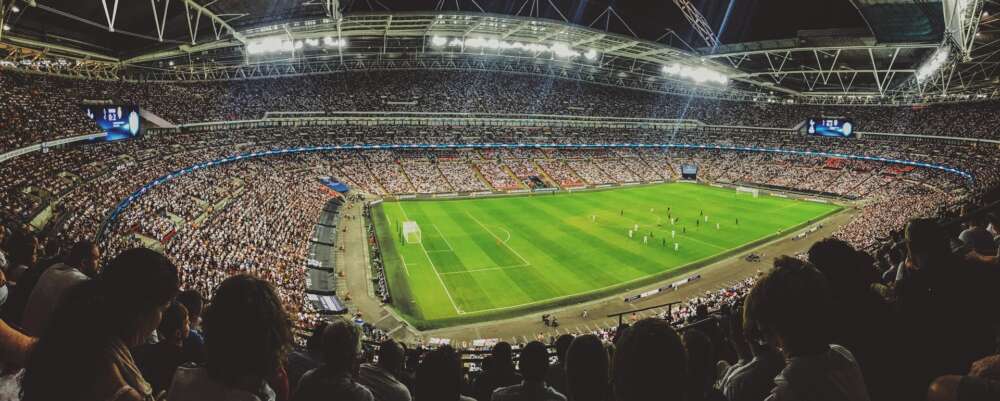 A wide shot of fans at a packed soccer stadium