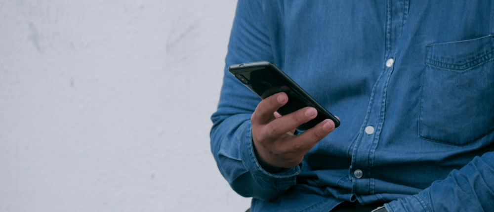 Person holding a smartphone. No visible faces can be seen.