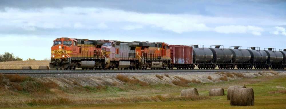 A freight train carrying oil drives across a prairie