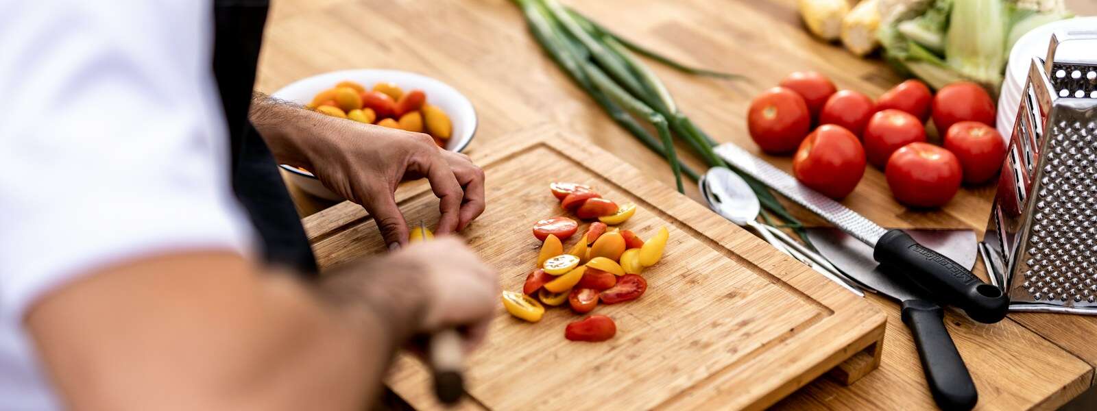 a person cutting up vegetables on a cutting board
