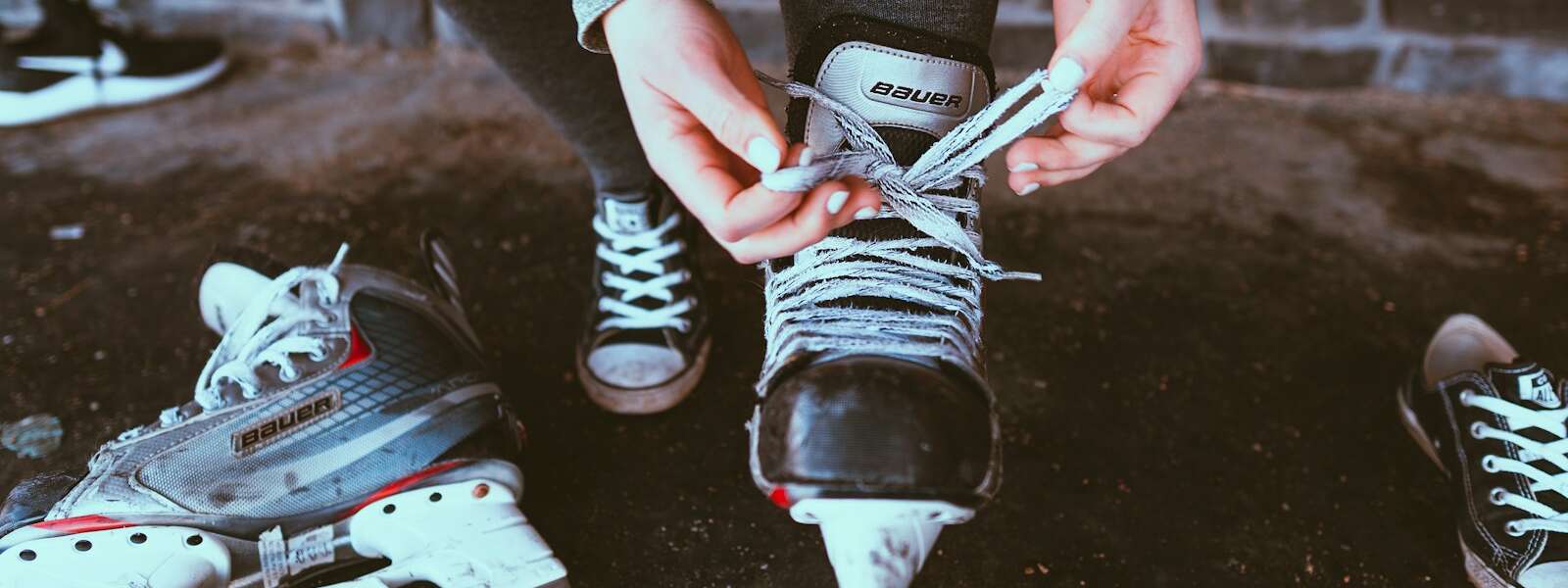person in black and white adidas sneakers holding white smartphone