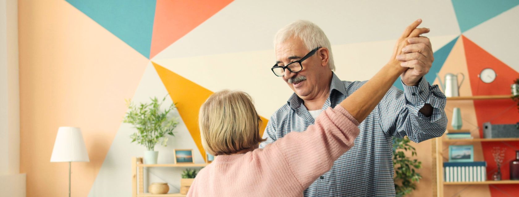 Elderly couple dances against a background