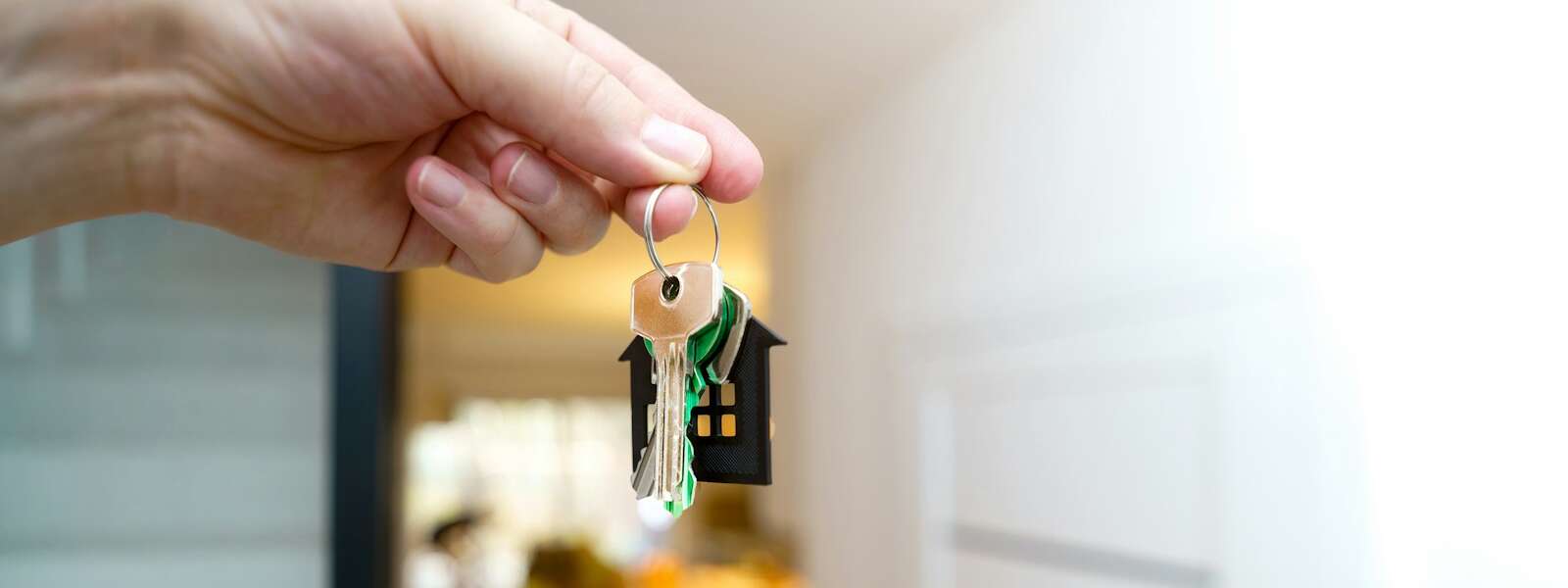 Holding house keys in front of the entrance.