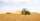 a tractor is plowing a field with a trailer